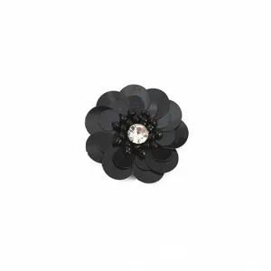 Vista detallada de un parche de flores con lentejuelas negras y centro de brillantes strass.