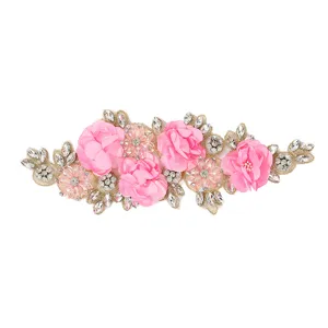Close-up detail of 3D pink flower embroidery lace patch with rhinestones for DIY crafts.