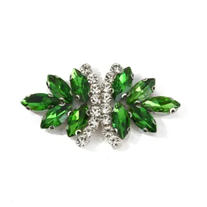 Green crystal rhinestone bow clothing accessory detail, sparkling glass stones for DIY shoes.