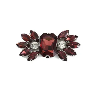 Close-up detail of sparkling dark red and clear glass rhinestone shoe buckle and DIY craft accessory.