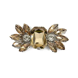Detailed close-up of decorative amber crystal rhinestone shoe buckle clothing accessory.