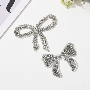 Close-up detail of sparkling rhinestone bow hotfix patches, perfect for DIY garment embellishments.