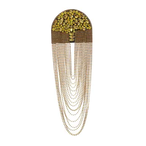 Close-up of gold rhinestone epaulette with hanging chains, detailed accessory shot for formal wear.
