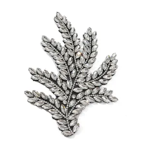 Gedetailleerde kristallen strass blad applicatie close-up, glanzende glazen diamant patch.