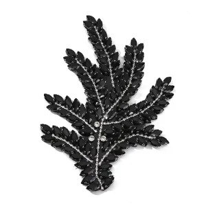 Close-up detail van zwarte strass blad applicatie met glanzende DIY decoratie.