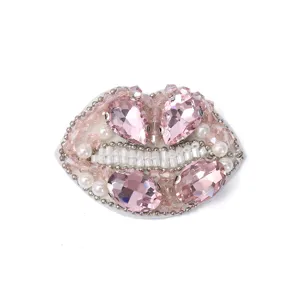 Close up of exquisite handmade beaded lips patch with sparkling pink rhinestones and pearls.