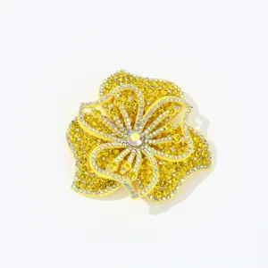 Detailed shot of yellow rhinestone floral patch, glitter crystal flower DIY clothing accessory.
