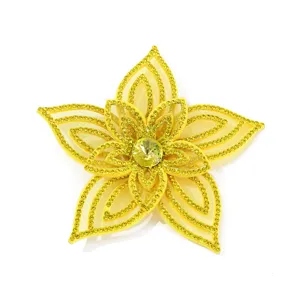 Detailed macro view of yellow rhinestone fabric flower applique for handmade DIY crafts.