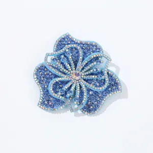 Detailed view of the blue rhinestone flower patch, showing sparkling crystal embellishments.