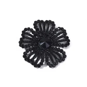 Close-up van zwart strass bloemenpatch detail, sprankelende kristallen applicatie accessoire.