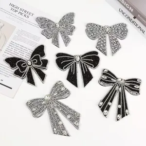 Detailansicht handgemachter Strass-Schleifen-Applikationen, glitzernde Kristall-Patches.