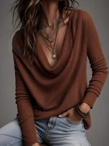 Detailaufnahme eines braunen Feinstrickpullovers mit Wasserfallausschnitt und Jeanshose.