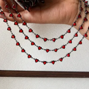 Dettaglio catena con pietre a cuore rosso, rame di qualità, ideale per creazione gioielli.