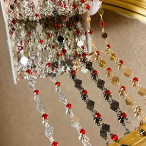 Primo piano di catene in metallo fai-da-te con diamanti e cristalli rossi per accessori da sposa.