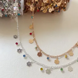DIY jewelry chain detail showing gold and silver metallic chains with flower and crystal charms.