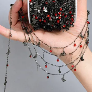 Close-up detail shot of DIY black chain with red rhinestones and cute butterfly charms accessories.