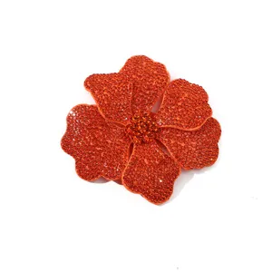 Orange rhinestone flower DIY accessory detail, shimmering glass crystal shoe and bag decoration.