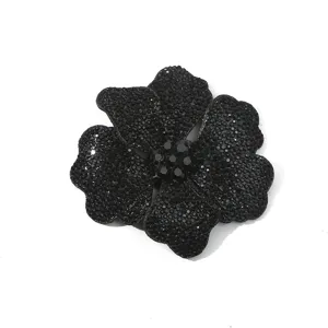 Detailed close-up of a black rhinestone flower accessory, sparkling glass crystal design.