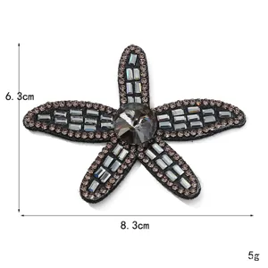 Dettaglio patch a stella marina in strass scintillanti, decorazione preziosa per abiti.