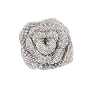 Exquisite rhinestone-paved camellia flower brooch, sparkling crystal floral clothing accessory detail.