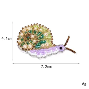 Handmade beaded snail embroidery patch DIY clothing accessory with sparkling rhinestones.
