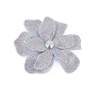 Close-up detail of sparkling rhinestone flower patch brooch with colorful center crystal.