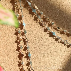 Dettaglio ravvicinato di catena metallica con strass a trifoglio DIY, accessorio brillante.