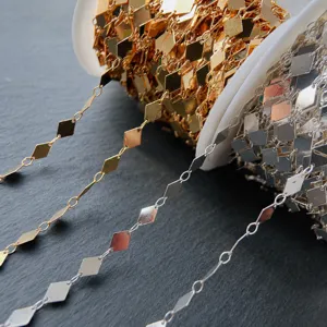 Nahansicht von metallischen Rhombusketten und Quastenmaterial für DIY Haarschmuck.