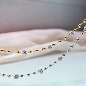 Close-up detail of DIY metallic beaded jewelry chains featuring sparkly rhinestone balls.