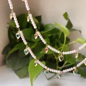 Detailed view of handmade pearl chain with sparkling colorful heart rhinestones for DIY.