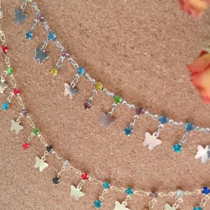 Close-up detail of DIY jewelry accessories featuring colorful rhinestone and butterfly chains.