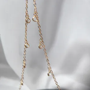 Close-up detail of gold copper chain with clear crystal pendants for DIY jewelry making.
