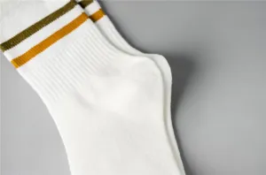 White mid-tube socks with green yellow stripes close up, breathable sports casual daily wear.