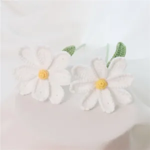 Handmade crochet daisy flower close up, cute knit floral decor detail for home and office styling.