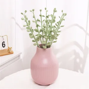 Close-up detail of handmade crochet fern leaves in a pink vase, perfect for cozy home decor.