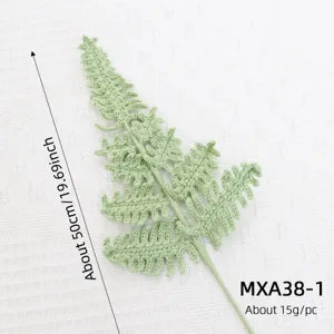 Detail shot of handmade knitted green fern leaf accessory, highlighting exquisite crochet details.