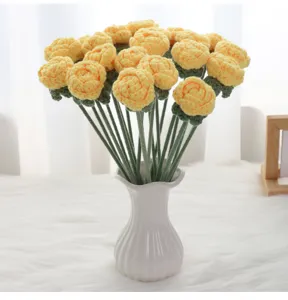 Primer plano detallado de ramo de rosas amarillas de ganchillo artesanal en florero.