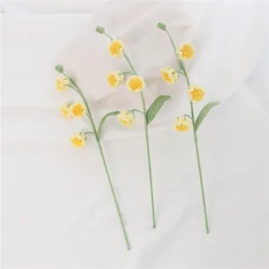 Handmade crochet yellow flower detail view, delicate yarn stem and leaf craftsmanship for gifts.