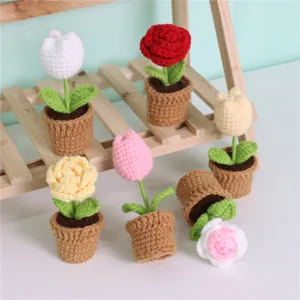 Gros plan de fleurs en pot crochetées à la main, mini décoration de table en fil tricoté.