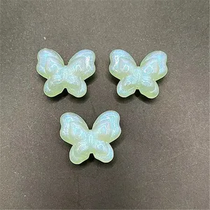 Gros plan detail de perles papillon en acrylique lumineuse avec trou vertical pour bijoux DIY.