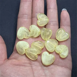 Close-up of acrylic cloudy heart beads with gold glitter for DIY jewelry making details