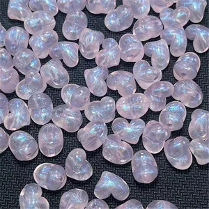 Primer plano de cuentas acrílicas de corazón de sirena rosa translúcido para joyería DIY.