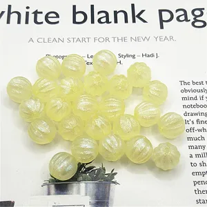 Gros plan de perles citrouille en acrylique jaune avec éclat nacré pour la fabrication de bijoux.