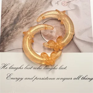 Breloques lune et papillon en resine pailletee dore pour fabrication de bijoux DIY et porte-cles.