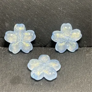 Blue translucent cherry blossom beads detail with gold glitter for DIY accessories and crafts.