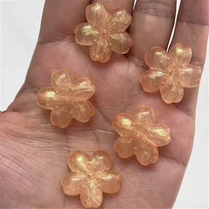 Close-up of glitter cherry blossom resin beads, perfect for DIY jewelry and phone charms.
