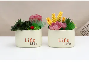 Detail shot of artificial succulent plants in white ceramic pots, home decor accessories.