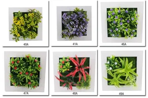 Vista dettagliata di cornici murali con piante artificiali, vari stili di verde succulento.