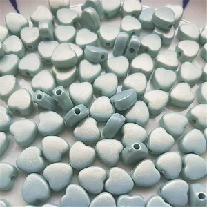 Detail shot of light blue iridescent heart beads, perfect for DIY jewelry and phone charms.