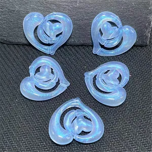 Vue rapprochée de charms DIY en forme de cœur creux irisé avec effet perlé et pailleté brillant.